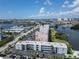 Real estate showing an aerial view of condo buildings with palm trees by a waterfront at 1859 Shore S Dr # 202, South Pasadena, FL 33707