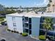 Condominium exterior showcasing well-maintained landscaping and private balconies under a sunny sky at 1859 Shore S Dr # 202, South Pasadena, FL 33707