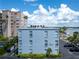 Exterior view of a building, parking lot, and surrounding buildings under a sunny sky at 1859 Shore S Dr # 202, South Pasadena, FL 33707