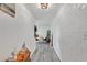 Light and airy hallway with light gray plank flooring and white brick walls leading to the dining area at 1859 Shore S Dr # 202, South Pasadena, FL 33707