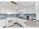 Contemporary kitchen with white cabinets, updated appliances, and decorative lighting fixture at 1859 Shore S Dr # 202, South Pasadena, FL 33707