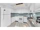 Updated kitchen with all-white cabinets, stylish backsplash, and stainless steel appliances at 1859 Shore S Dr # 202, South Pasadena, FL 33707