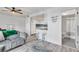 Inviting living room with gray plank flooring, white walls, gray sofas, a kitchen view, and bathroom access at 1859 Shore S Dr # 202, South Pasadena, FL 33707