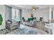 Modern living room with gray sofas, ceiling fan, and view of the dining area and bright window at 1859 Shore S Dr # 202, South Pasadena, FL 33707