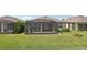 Green backyard featuring a screened in patio with outdoor furniture and lake views for relaxed outdoor living at 19183 Coastal Shore Ter, Land O Lakes, FL 34638