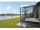 View of a backyard with a screened patio overlooking a serene lake, blending indoor and outdoor living seamlessly at 19183 Coastal Shore Ter, Land O Lakes, FL 34638