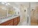 Bathroom showcasing a double vanity with granite countertops, decorative lighting, walk-in shower and closet at 19183 Coastal Shore Ter, Land O Lakes, FL 34638