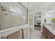 Bright bathroom featuring a walk-in shower, granite countertop, and a view into the main bedroom at 19183 Coastal Shore Ter, Land O Lakes, FL 34638