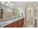 Bathroom featuring a double vanity with granite countertops, decorative lighting, and a walk-in shower at 19183 Coastal Shore Ter, Land O Lakes, FL 34638