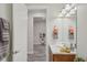 Bright bathroom featuring a white vanity, decorative mirror, and modern lighting fixtures at 19183 Coastal Shore Ter, Land O Lakes, FL 34638