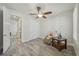 Neutral bedroom with wood-look flooring, fan, and access to ensuite bath and walk-in closet at 19183 Coastal Shore Ter, Land O Lakes, FL 34638