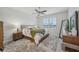 Bright bedroom features a large window with plantation shutters, a ceiling fan, and neutral decor at 19183 Coastal Shore Ter, Land O Lakes, FL 34638