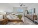 Comfortable bedroom with a ceiling fan, dresser with mirror, soft rug, and window for ample natural light at 19183 Coastal Shore Ter, Land O Lakes, FL 34638