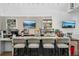 Modern coffee bar with marble countertops, seating and flat screen TV at 19183 Coastal Shore Ter, Land O Lakes, FL 34638