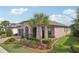 Inviting front entrance with an arched entryway, stone accents, and manicured landscaping at 19183 Coastal Shore Ter, Land O Lakes, FL 34638