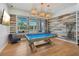 Entertaining game room with a pool table, wood-style accent wall, and lots of natural light at 19183 Coastal Shore Ter, Land O Lakes, FL 34638