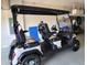 White golf cart with black seats parked inside the garage at 19183 Coastal Shore Ter, Land O Lakes, FL 34638