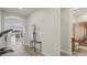 Bright hallway with wood-look tile floors, decorative table, and views of the living room and an adjacent bathroom at 19183 Coastal Shore Ter, Land O Lakes, FL 34638