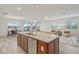 Open kitchen featuring a large island with a granite countertop, a stainless steel dishwasher, and pendant lighting at 19183 Coastal Shore Ter, Land O Lakes, FL 34638
