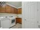Convenient laundry room featuring modern appliances and ample storage cabinets at 19183 Coastal Shore Ter, Land O Lakes, FL 34638