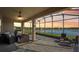 Enclosed outdoor patio with a ceiling fan and beautiful lake views at 19183 Coastal Shore Ter, Land O Lakes, FL 34638