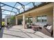 Inviting screened patio with a cozy fire pit, comfortable seating, ceiling fan, and scenic outdoor views at 19183 Coastal Shore Ter, Land O Lakes, FL 34638