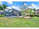 A covered outdoor patio and well-maintained landscaping in a lush backyard setting at 20106 Bending Creek Pl, Tampa, FL 33647