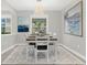 Charming dining room with a wooden table, stylish chandelier, and sunlit windows showcasing a vibrant greenery at 20106 Bending Creek Pl, Tampa, FL 33647