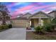 Inviting single-Gathering home featuring a beige exterior, well-manicured lawn, and two-car garage at 20106 Bending Creek Pl, Tampa, FL 33647