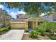 Charming home featuring a two-car garage, inviting front porch, and lush landscaping at 20106 Bending Creek Pl, Tampa, FL 33647