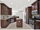 Spacious kitchen with dark wood cabinets, granite counters, stainless appliances, and central island at 20106 Bending Creek Pl, Tampa, FL 33647