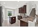 Charming kitchen featuring dark cabinets, granite countertops, and stainless steel sink at 20106 Bending Creek Pl, Tampa, FL 33647