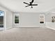 Spacious living room with a ceiling fan, carpeted floors, and a large sliding door that allows in plenty of natural light at 20106 Bending Creek Pl, Tampa, FL 33647