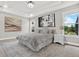 Well-lit main bedroom features stylish decor, carpet, tray ceiling and two windows framing lush greenery and a glimpse of the sky at 20106 Bending Creek Pl, Tampa, FL 33647