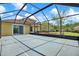 A spacious screened patio with a view of the backyard and blue skies at 20106 Bending Creek Pl, Tampa, FL 33647