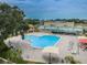 Aerial view of the community pool featuring plenty of lounge chairs and colorful umbrellas at 2073 Denmark St # 9, Clearwater, FL 33763