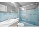 Bathroom with blue-tiled walls, toilet, and sink has a shower and tub combo at 2073 Denmark St # 9, Clearwater, FL 33763