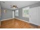 Bedroom featuring wood look floors, ceiling fan and a white sliding barn door at 2073 Denmark St # 9, Clearwater, FL 33763