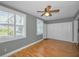 Bedroom featuring a ceiling fan, wood-look floors, and spacious closet space at 2073 Denmark St # 9, Clearwater, FL 33763
