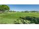 Lush green golf course with a flag on a clear, sunny day, framed by trees and distant buildings at 2073 Denmark St # 9, Clearwater, FL 33763