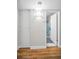 Hallway with wood floors leads to bathroom with tiled shower at 2073 Denmark St # 9, Clearwater, FL 33763