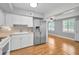 Bright, eat-in kitchen with white cabinets, wood-look flooring, and stainless steel refrigerator at 2073 Denmark St # 9, Clearwater, FL 33763