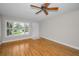 Bright living room with wooden floors, ceiling fan and large windows with white shutters at 2073 Denmark St # 9, Clearwater, FL 33763