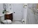 This bathroom offers a modern vanity with gold fixtures, a round mirror, and marble-style tiling in the shower at 2219 Thrace St, Tampa, FL 33605