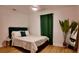 A well lit bedroom featuring a queen bed, stylish decor, and hardwood floors creating a cozy ambiance at 2219 Thrace St, Tampa, FL 33605