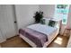 This cozy bedroom features white walls, light wood floors, a bed with stylish pillows and a pink stool accent at 2219 Thrace St, Tampa, FL 33605