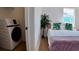 The bedroom features a bed, a modern washer/dryer closet and a window providing natural light at 2219 Thrace St, Tampa, FL 33605
