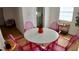 Bright dining area features pink acrylic chairs, a white table and a small wine bar at 2219 Thrace St, Tampa, FL 33605
