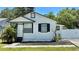 Charming single-Gathering home featuring a fresh white exterior, black trim and a well-manicured front yard at 2219 Thrace St, Tampa, FL 33605