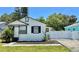 Charming single-Gathering home featuring a fresh white exterior, black trim, and an inviting, manicured front yard at 2219 Thrace St, Tampa, FL 33605